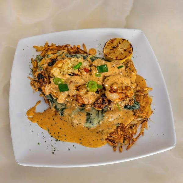 Milk & Honey's shrimp and grits with hash browns, spinach, and a grilled lemon.
